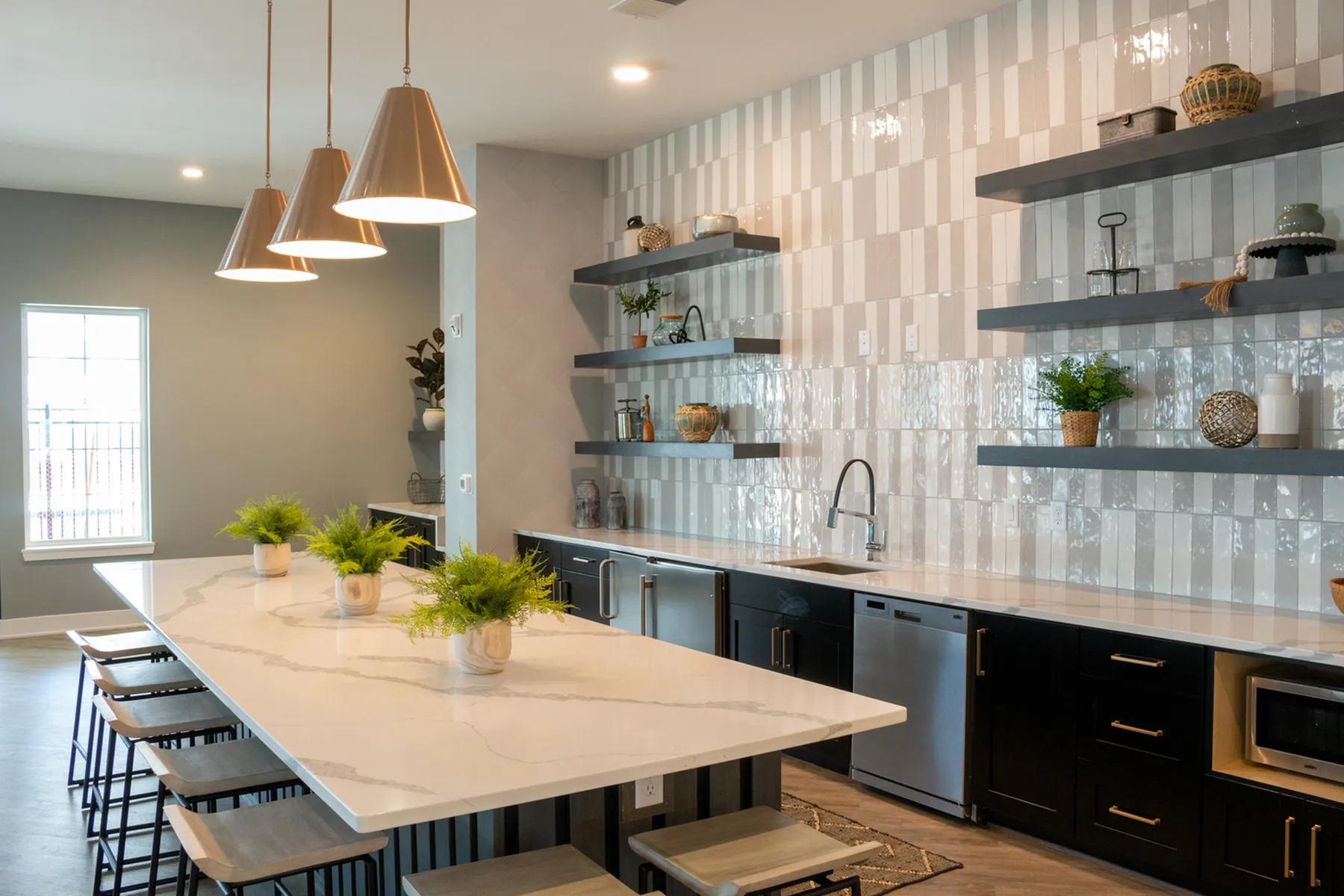 Chic, contemporary kitchen with sleek countertops, hanging pendant lights, and stylish open shelving.