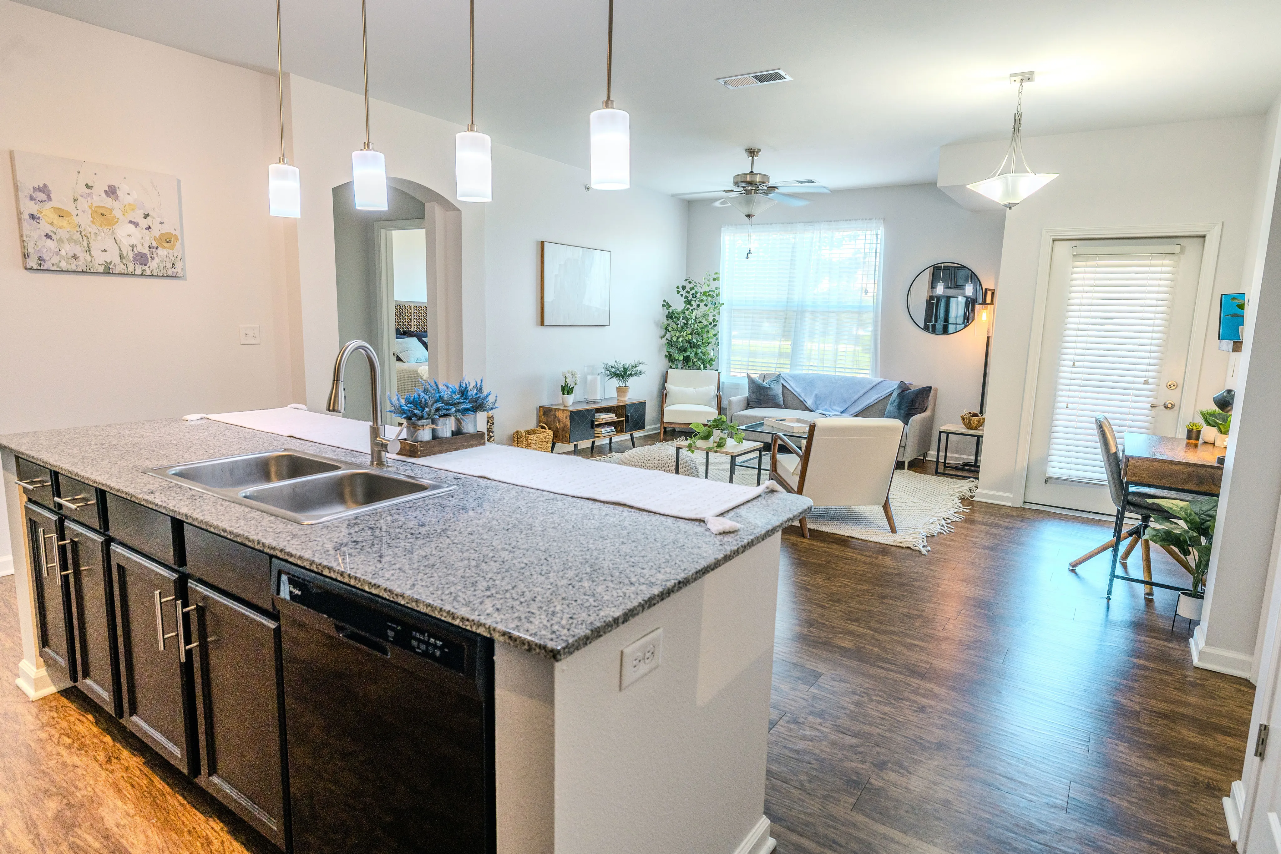 Chic and modern open-concept living space featuring a sleek kitchen island, cozy seating area, and abundant natural light.