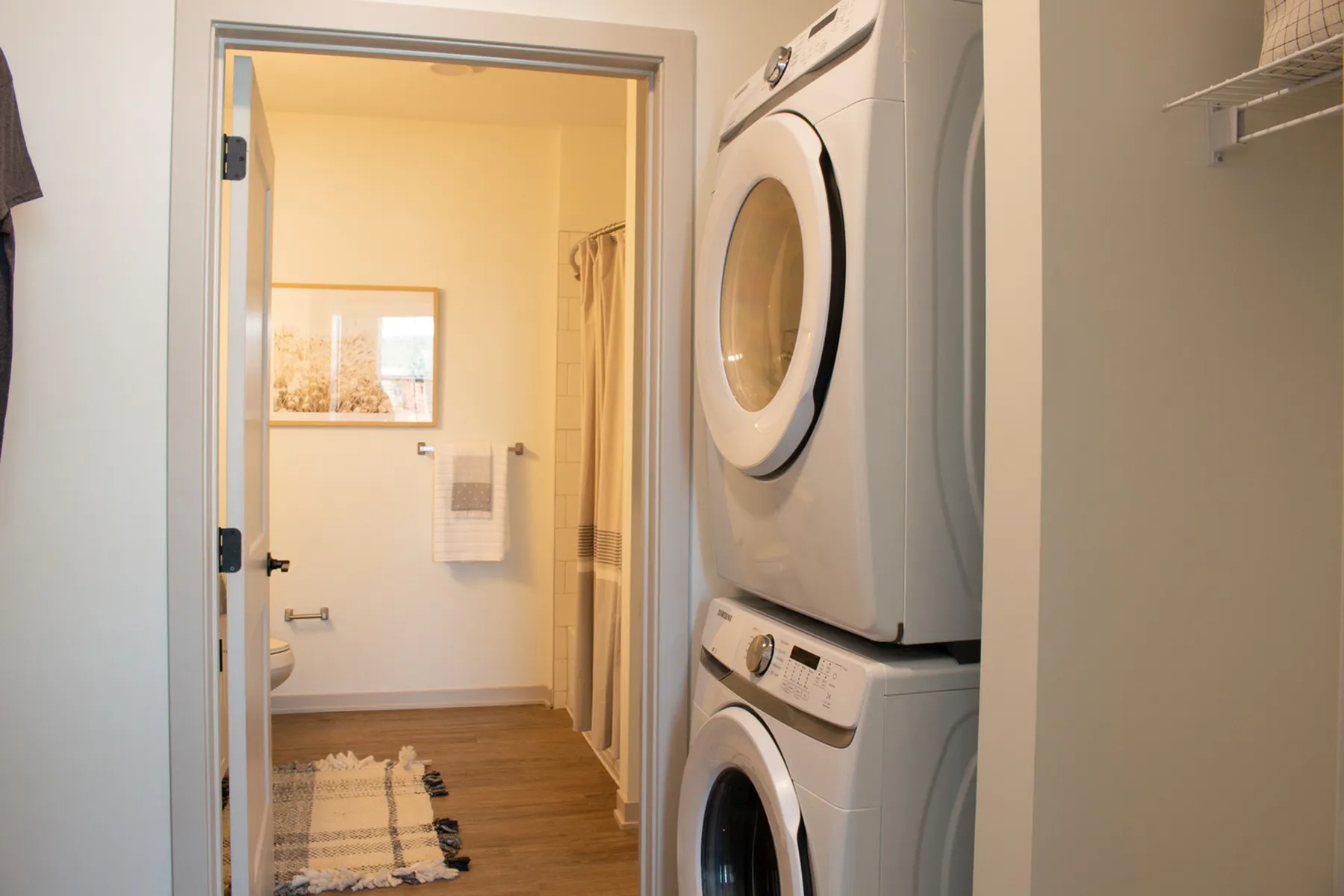Modern apartment with in-unit washer and dryer, leading into a stylish bathroom with chic decor.