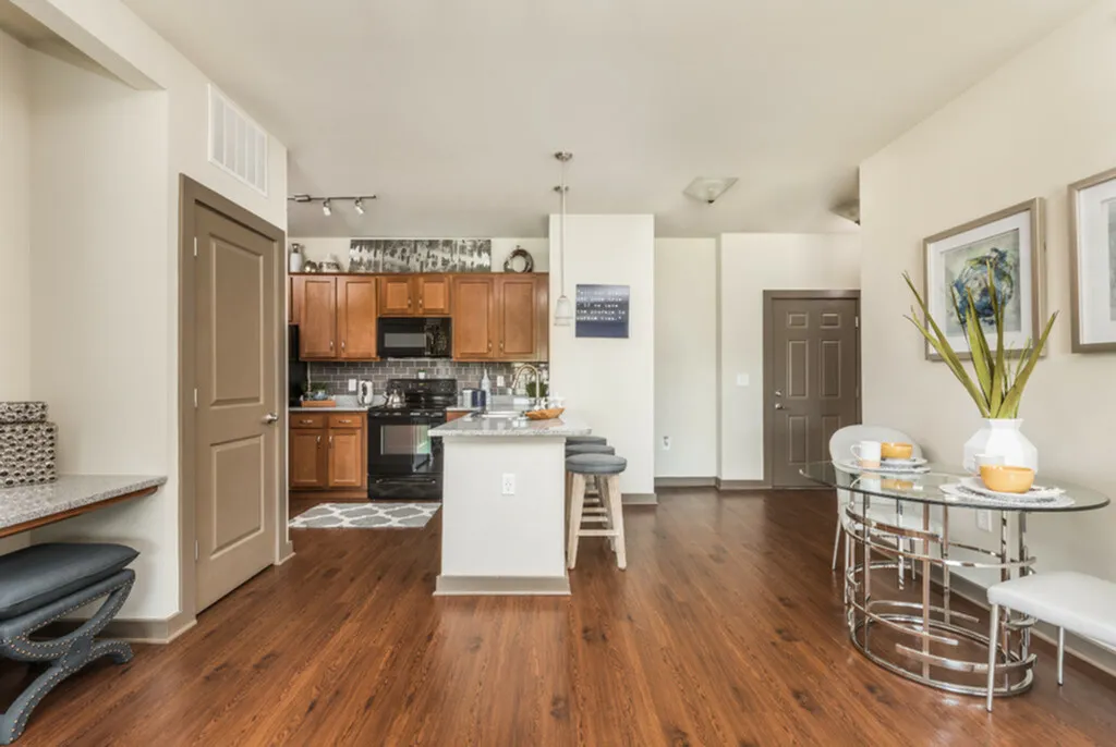 Chic, open-concept kitchen and dining area with modern wooden cabinets, sleek countertops, and elegant hardwood floors.