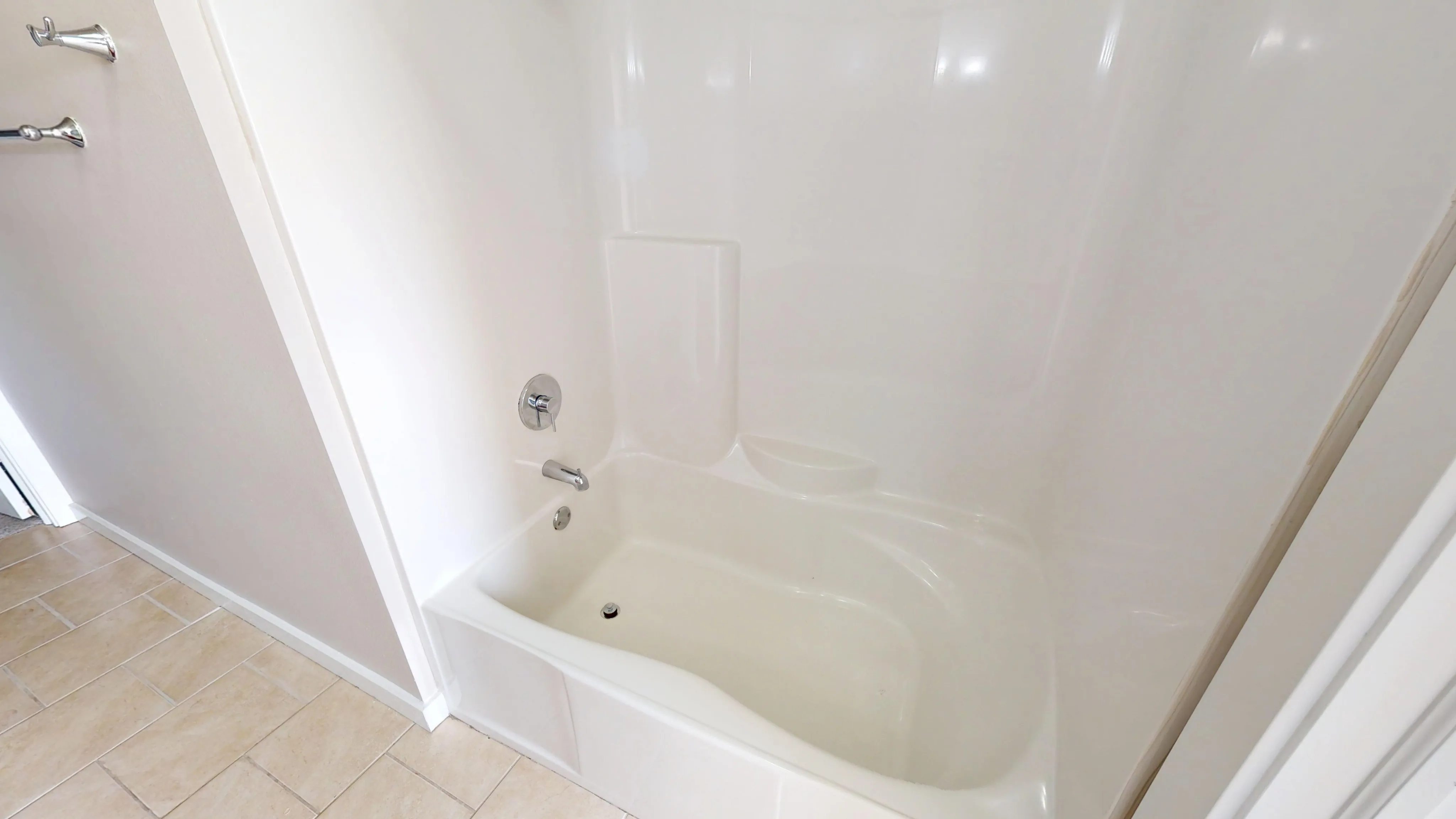 Elegant bathroom with a pristine white bathtub featuring modern fixtures and sleek tile flooring.