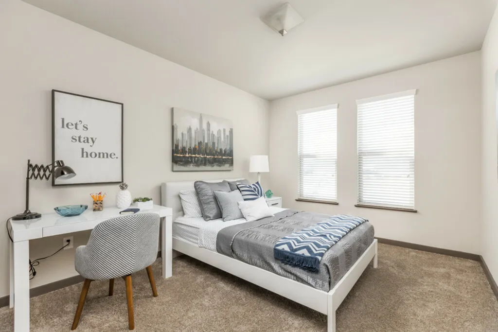 Cozy and bright bedroom with modern decor, featuring a comfortable bed, stylish desk, and large windows for natural light.