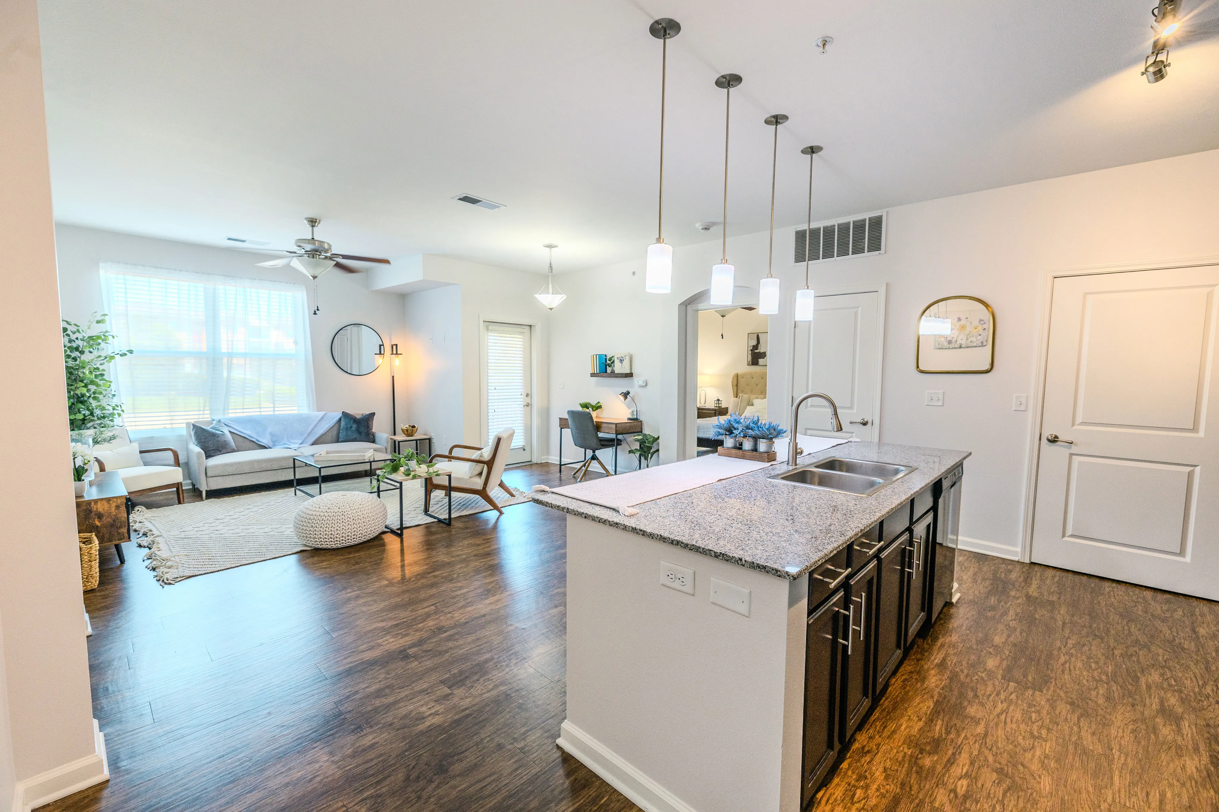 Bright and modern open-concept apartment with stylish kitchen island, cozy living room, and elegant decor.
