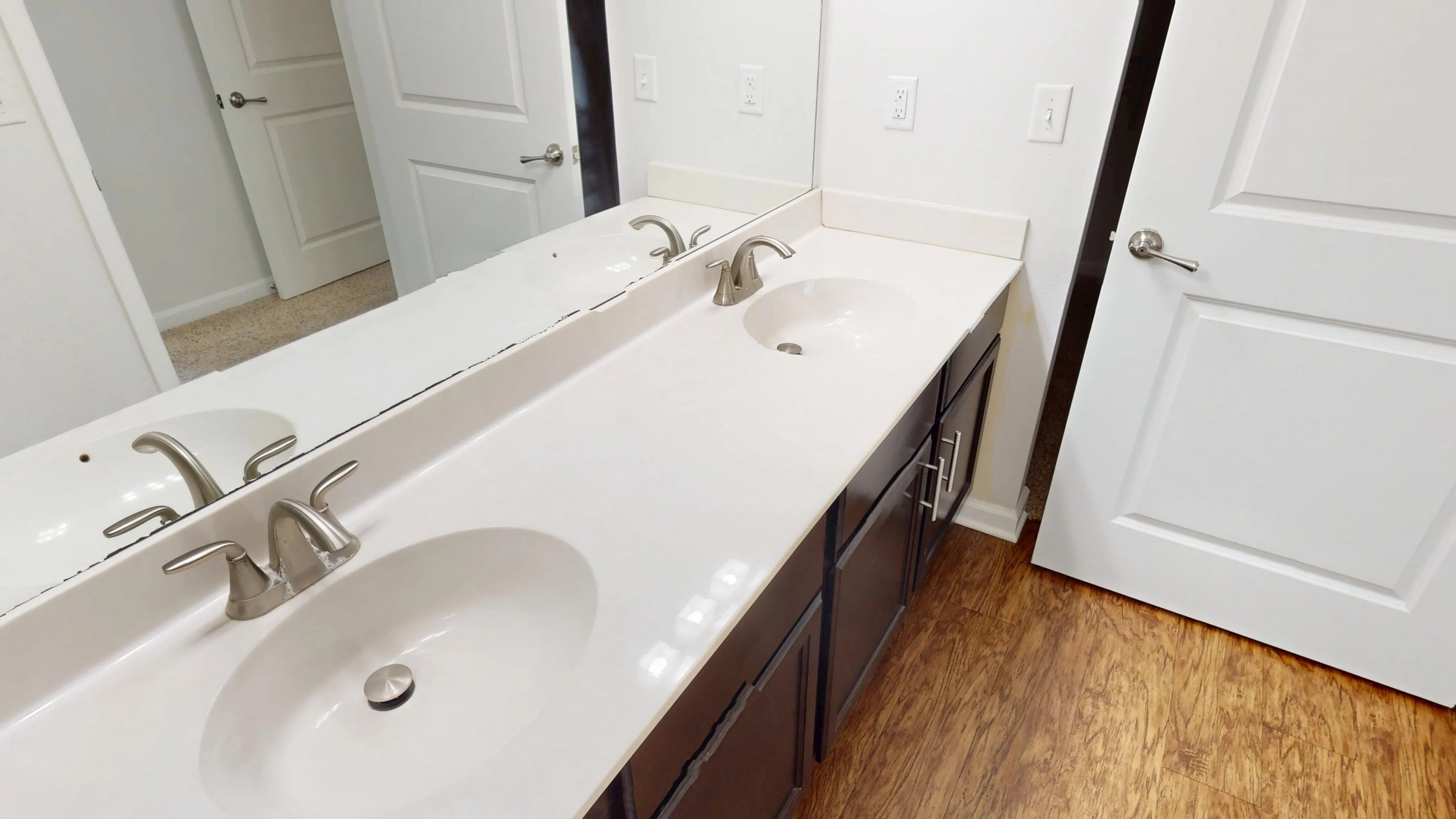 Elegant bathroom with dual sinks, sleek fixtures, and a large mirror, showcasing modern design and functionality.