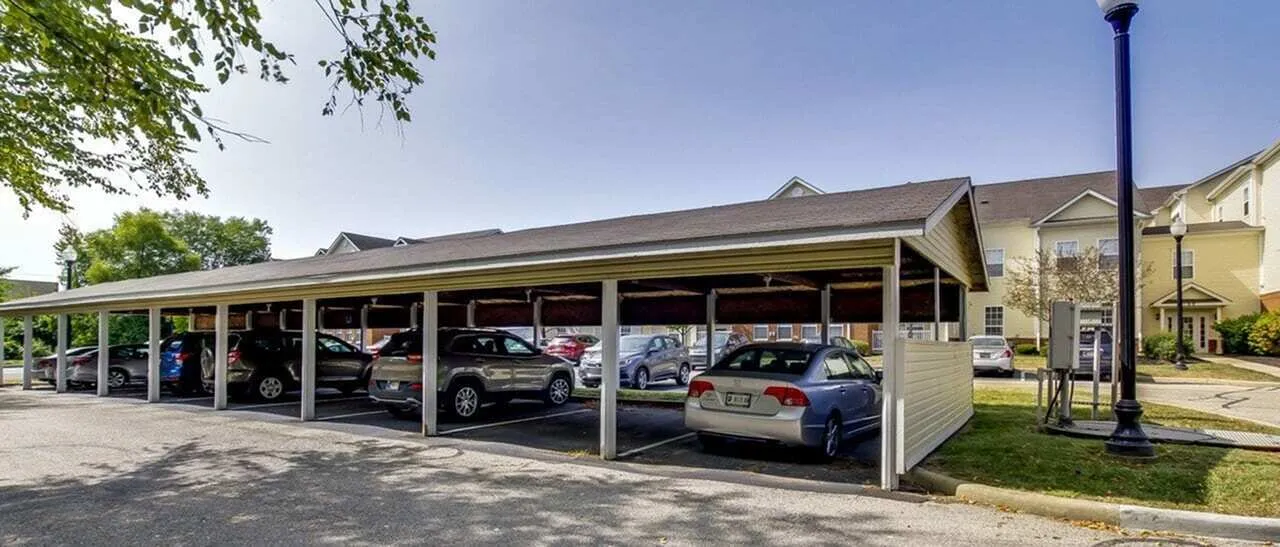 Charming covered parking area in a serene residential neighborhood, offering convenient and secure vehicle storage amidst lush surroundings.