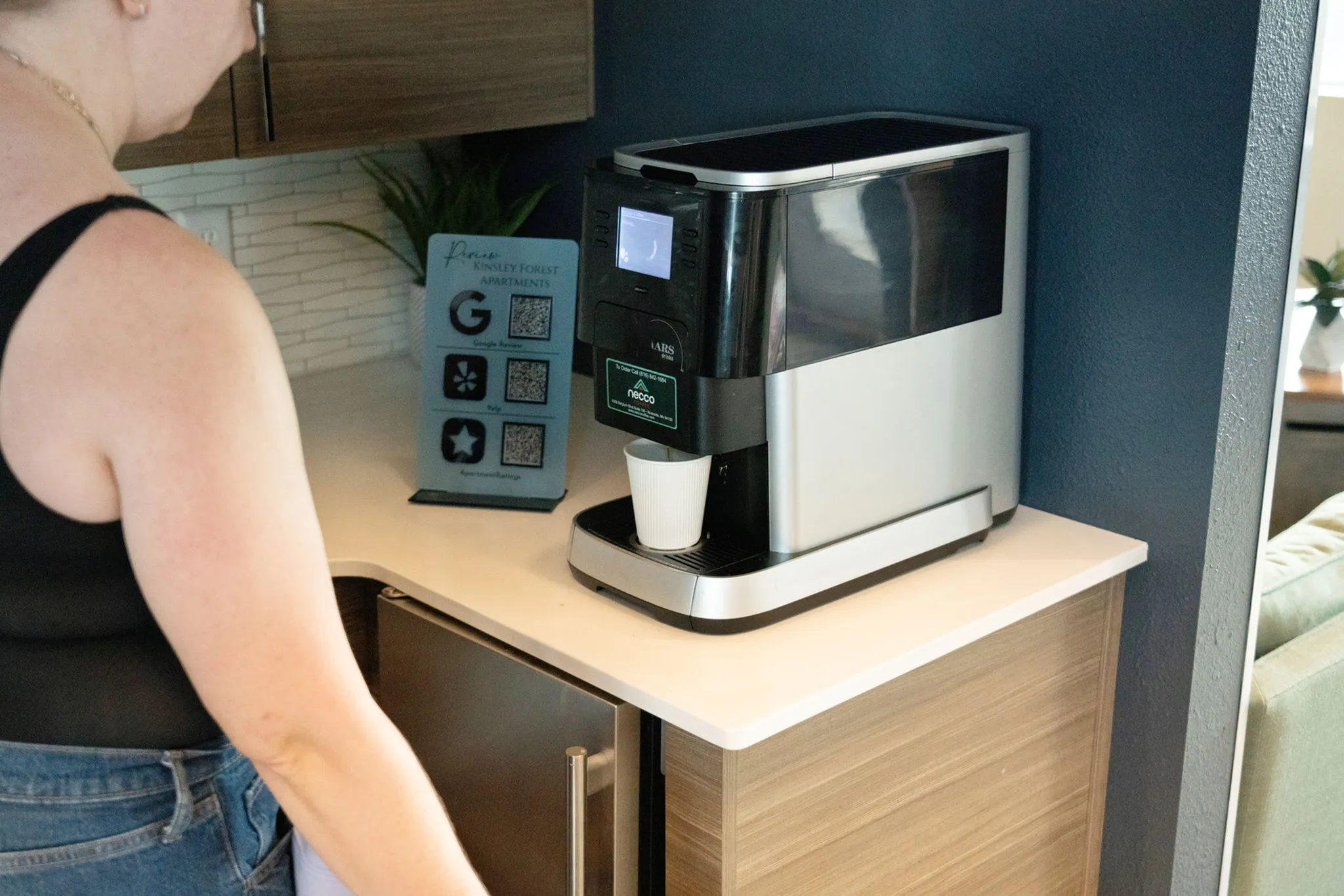 Inviting apartment space featuring a sleek modern coffee machine on a stylish kitchen counter, promising comfort and convenience.