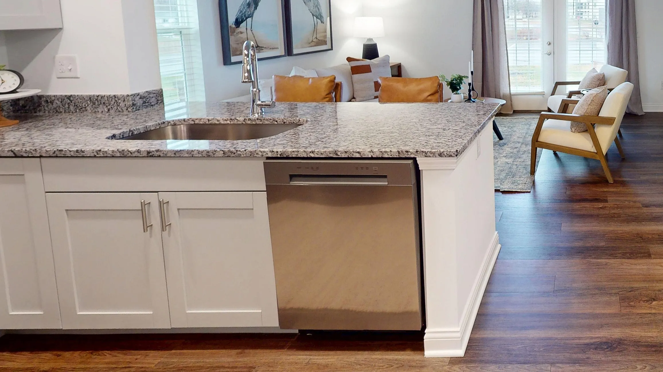 Chic open-concept living space featuring a modern kitchen with granite countertops, sleek dining area, and cozy living room with stylish decor.