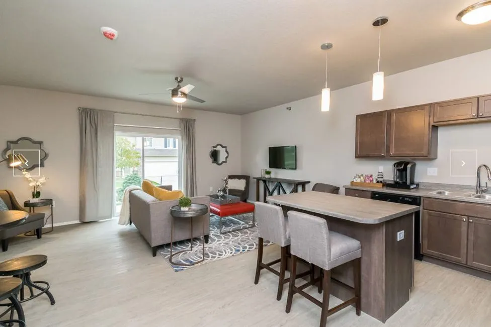 Contemporary living space showcasing open-concept design with modern kitchen, cozy seating, and large windows.
