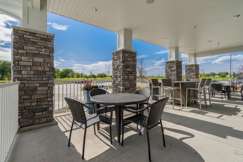 Inviting outdoor patio with elegant stone pillars, stylish seating, and scenic views, perfect for relaxation and gatherings.