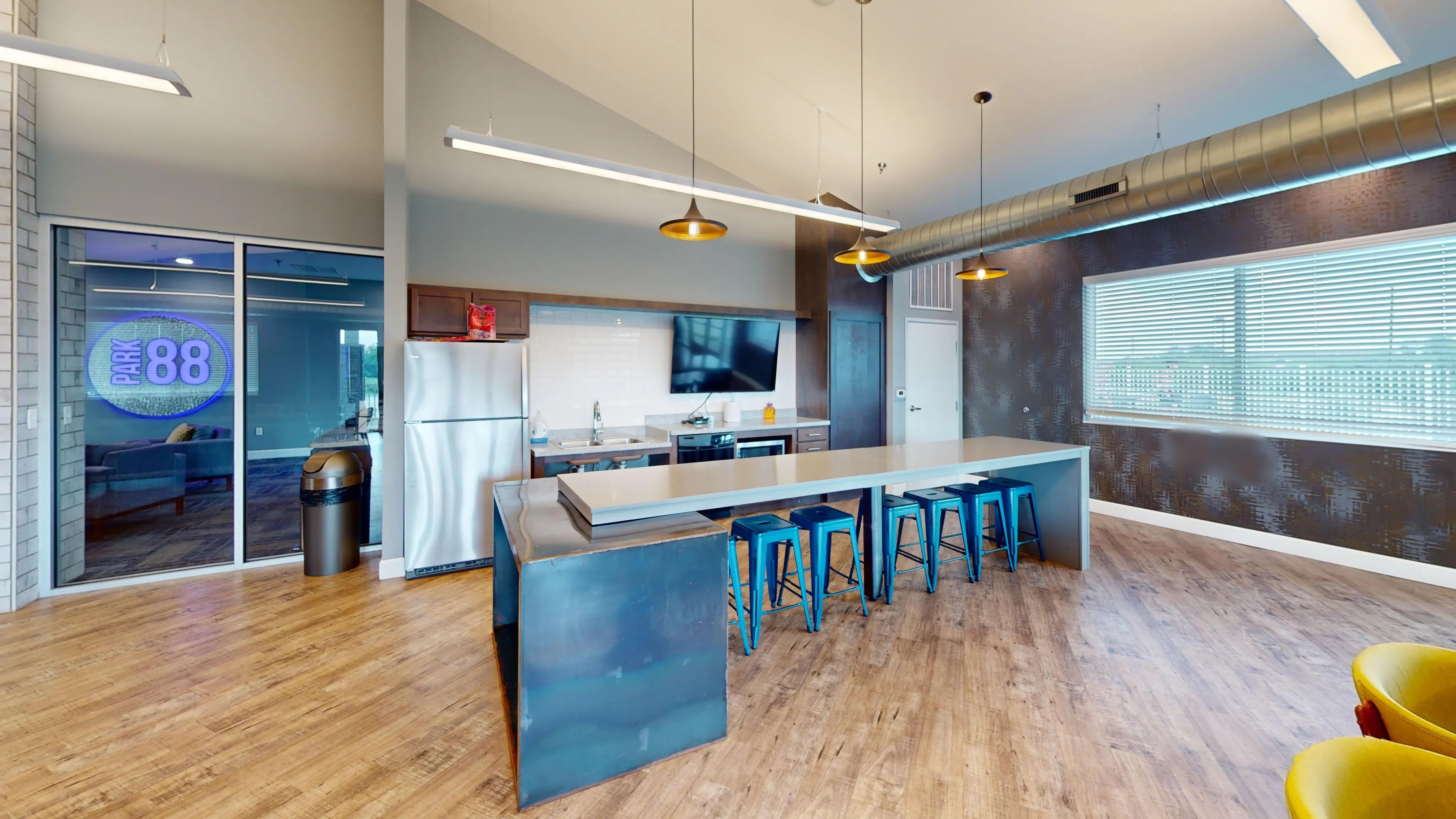 Modern kitchen with sleek countertops, stainless steel appliances, and vibrant bar stools, ideal for entertaining.