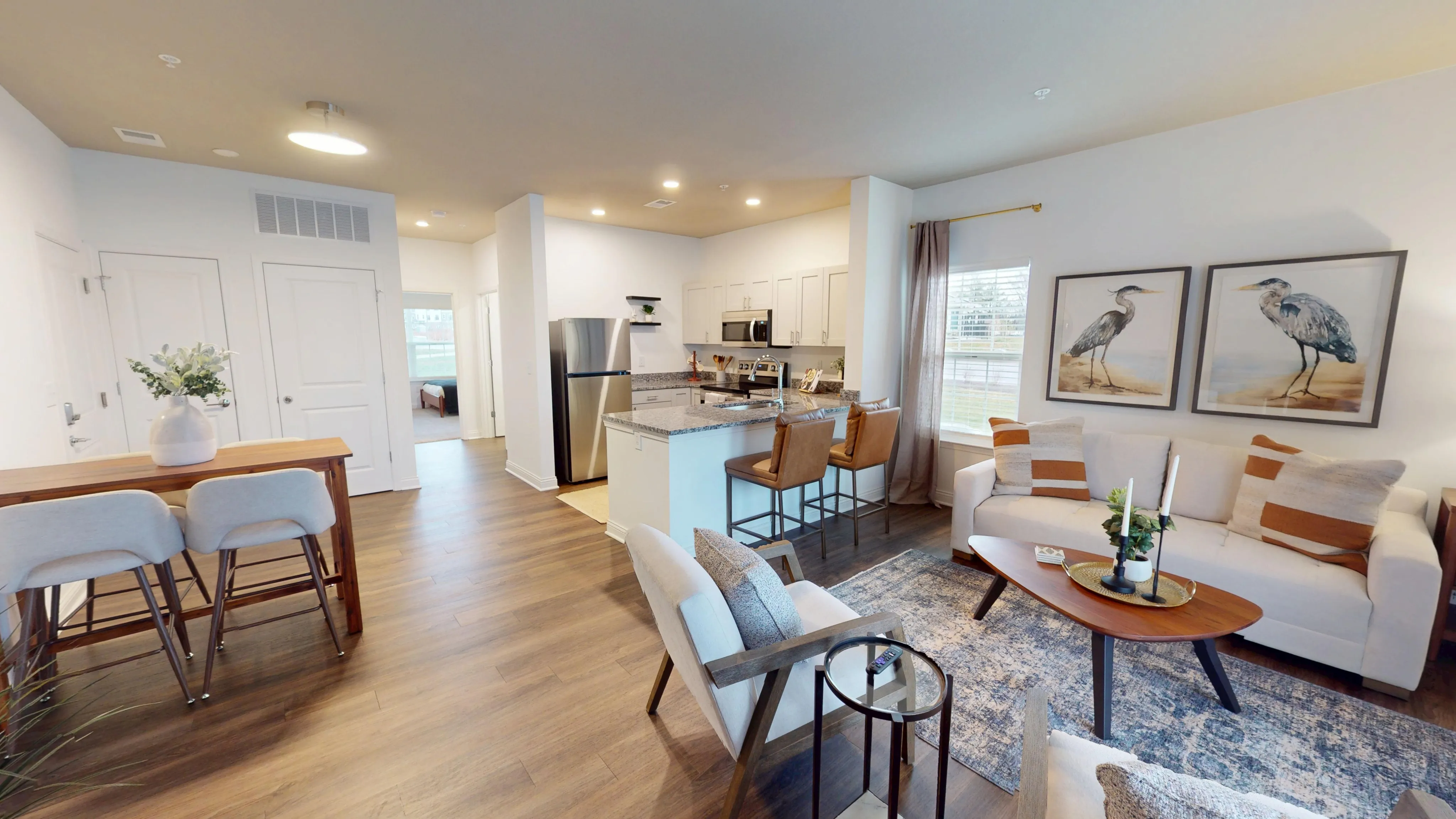 Charming open-concept apartment featuring a stylish kitchen with granite countertops, cozy living area with elegant decor, and inviting dining space with natural light.
