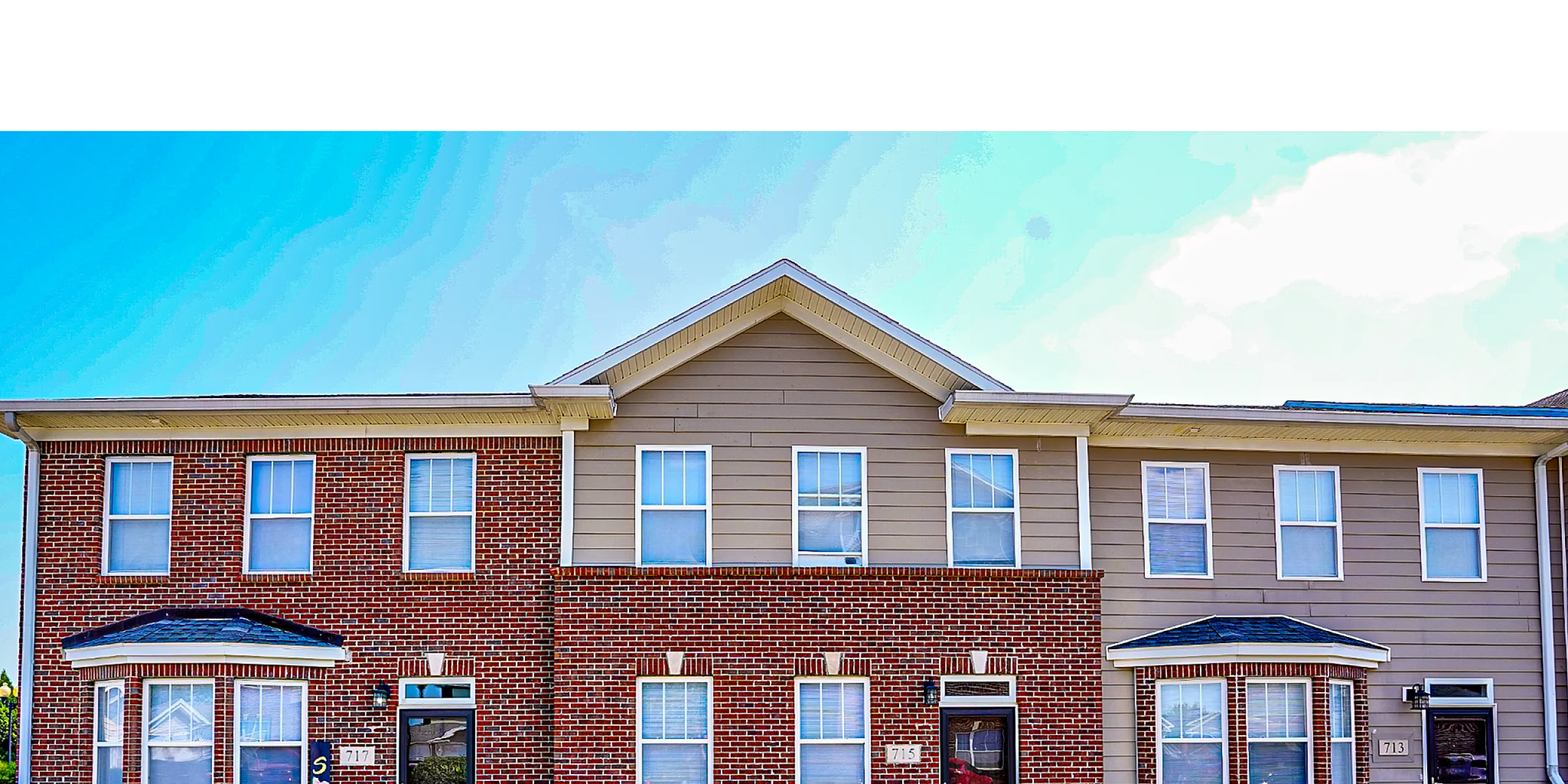 Charming townhouse exterior with inviting brick fa&ccedil;ade and classic window design perfect for modern living.