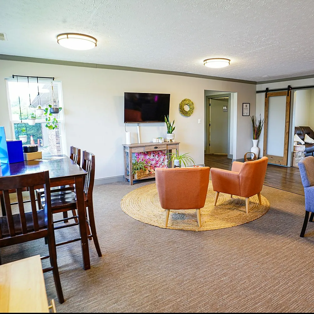 Inviting living space showcasing modern seating, vibrant plant decor, and ample natural light, perfect for relaxation and social gatherings.