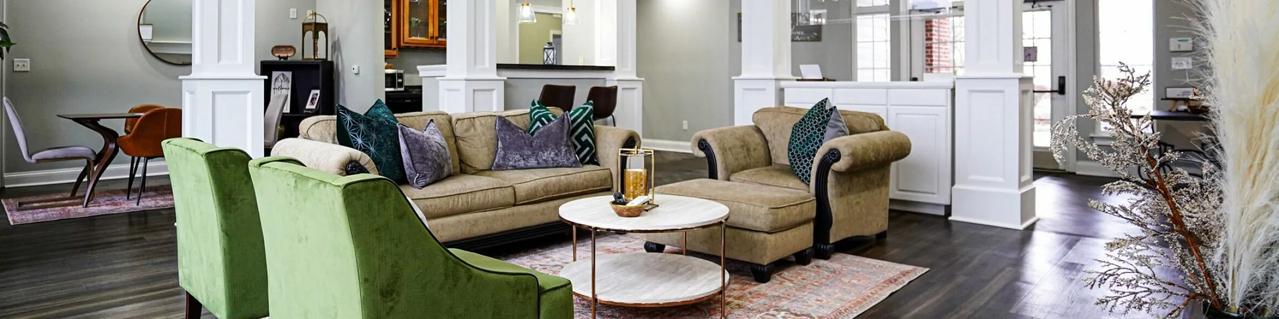 Elegant open-concept living space with stylish sofas, vibrant green chairs, and a modern ceiling design, highlighting a chic dining area and sophisticated decor.
