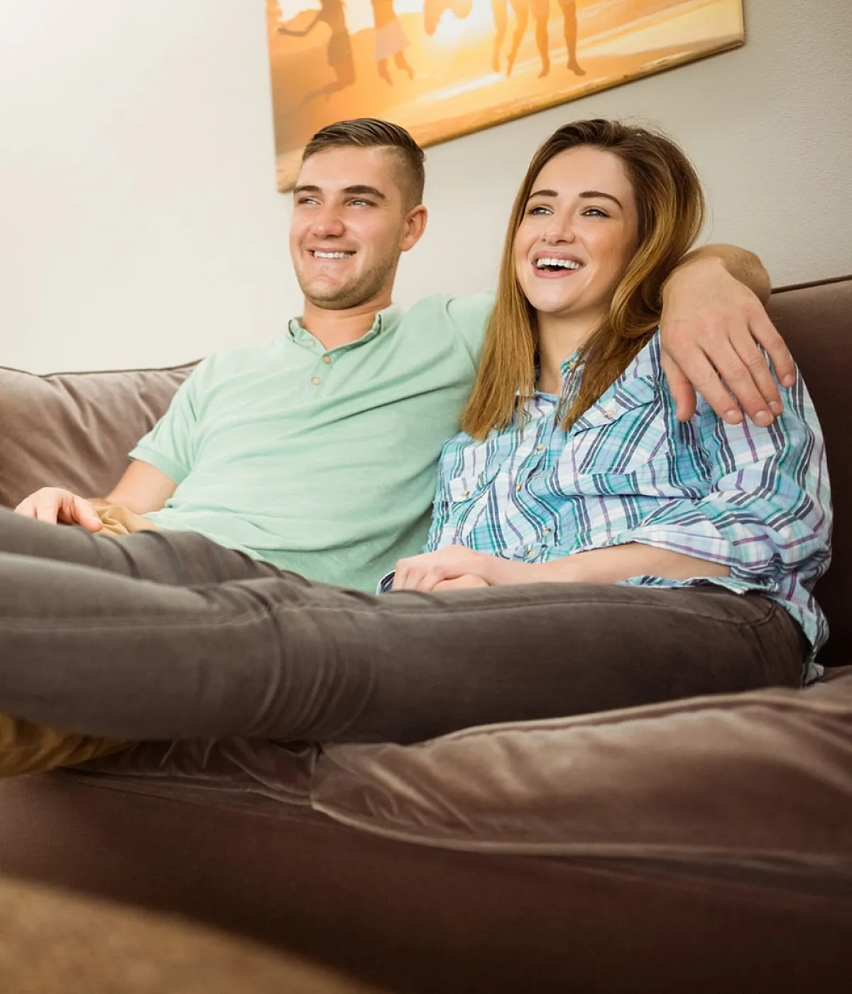 Young couple relaxing on a comfortable couch in a cozy living room with modern decor.