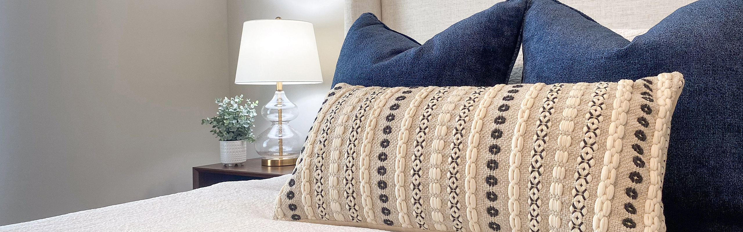 Elegant bedroom with plush bedding, decorative pillows, and ambient lighting for a cozy atmosphere.