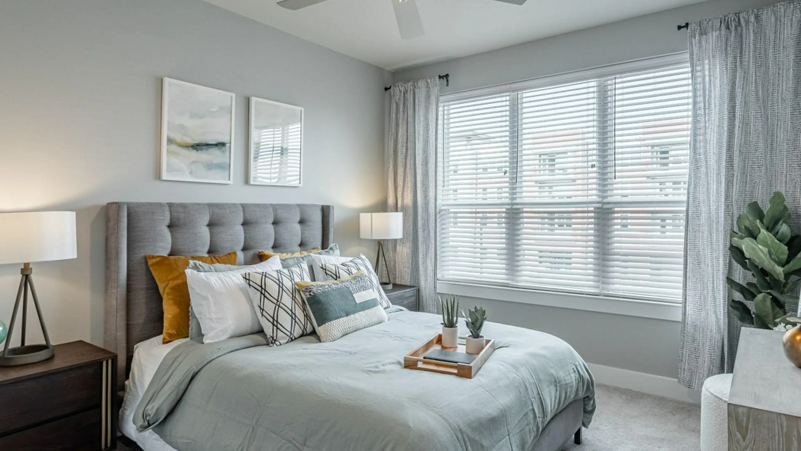 Charming bedroom with modern decor featuring a cozy bed, elegant lighting, and a large window allowing natural light to flood the space.