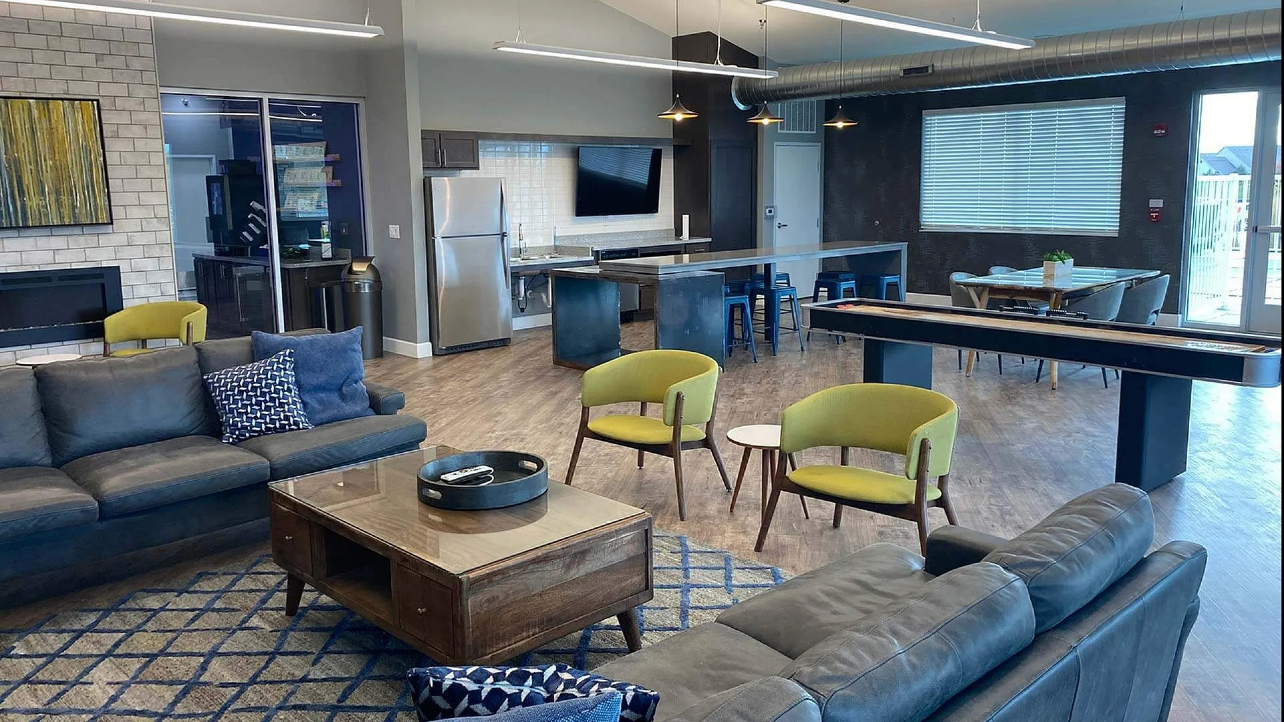 Chic and contemporary open-concept lounge with modern seating, vibrant decor, and a sleek kitchen area, perfect for relaxation and entertaining.
