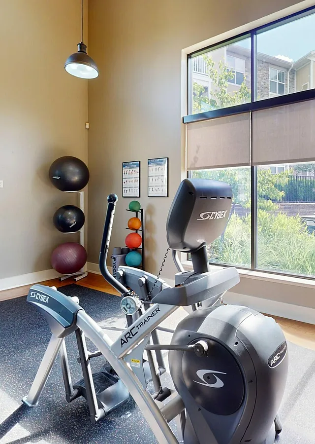 Bright fitness center featuring state-of-the-art gym equipment with a scenic view through large windows.