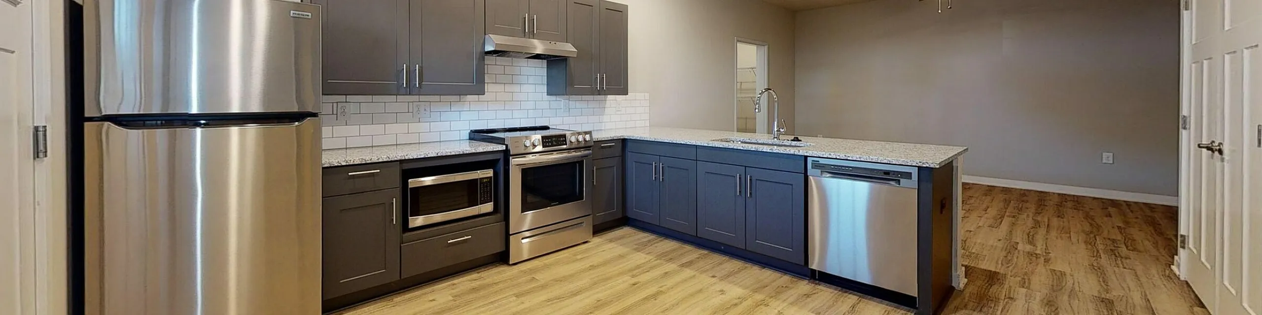 Modern kitchen with sleek stainless steel appliances, spacious countertops, and elegant cabinetry in an open-concept layout.