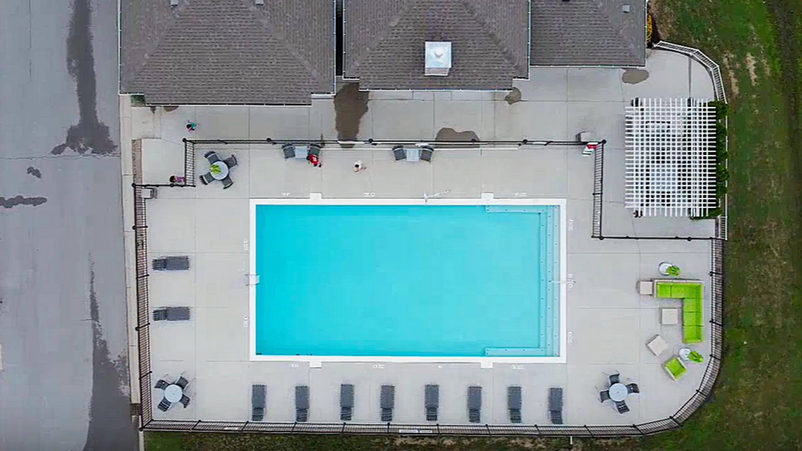 Aerial view of a luxurious swimming pool surrounded by lounging chairs and vibrant outdoor seating, perfect for relaxation and social gatherings.