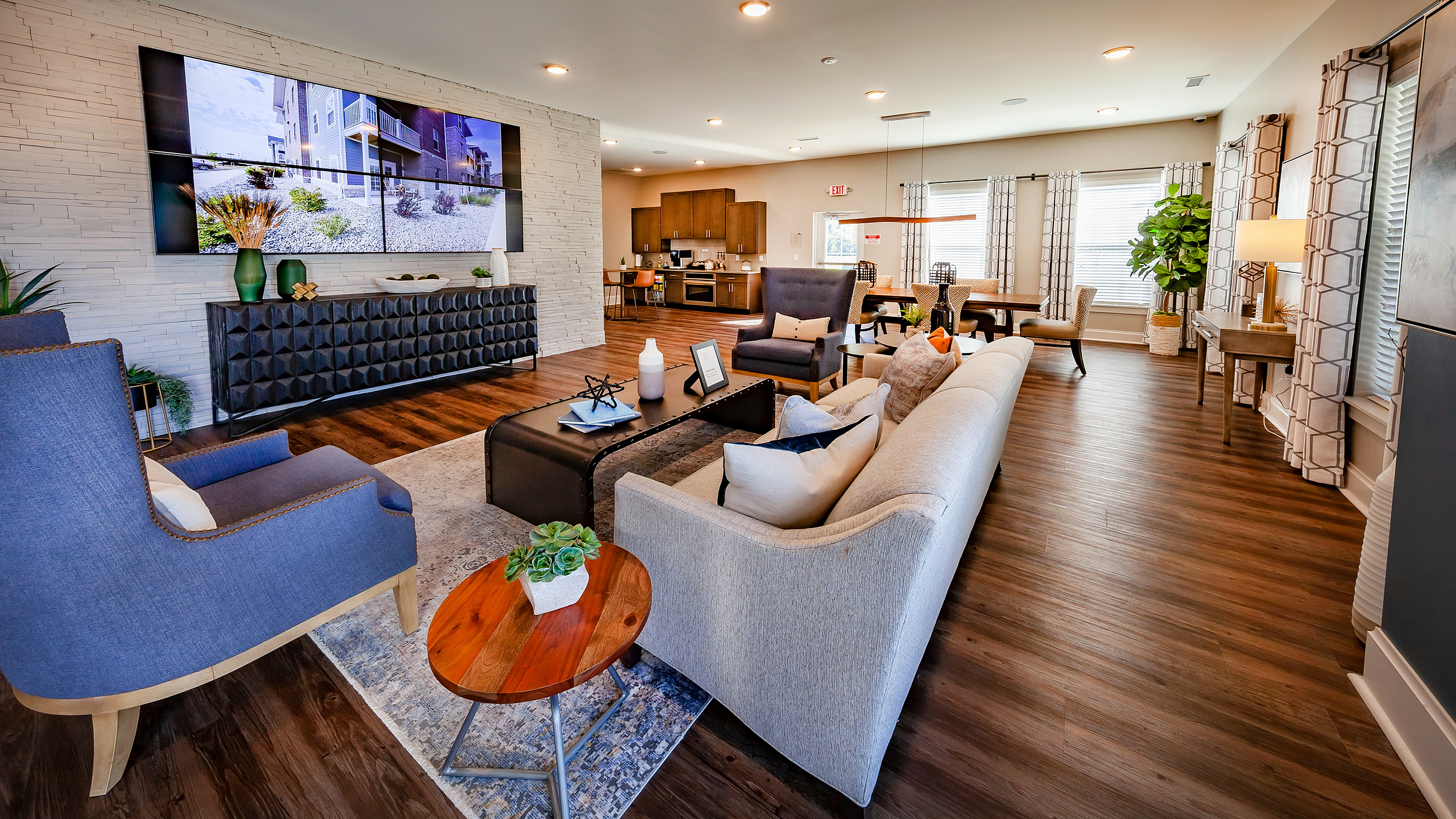 Luxurious open-concept living room with stylish furniture, rich wooden flooring, and bright natural light creating a warm and inviting atmosphere.