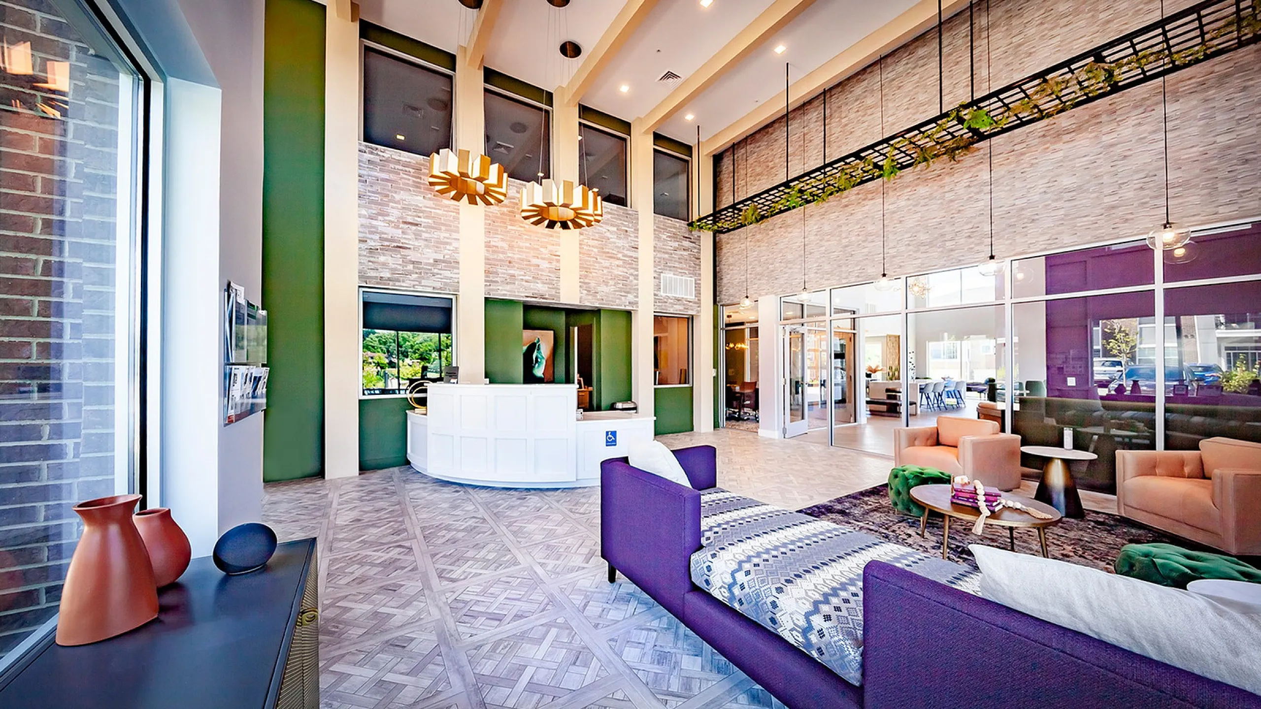 Elegant apartment lobby with high ceilings, modern lighting, and stylish seating area, perfect for welcoming guests.