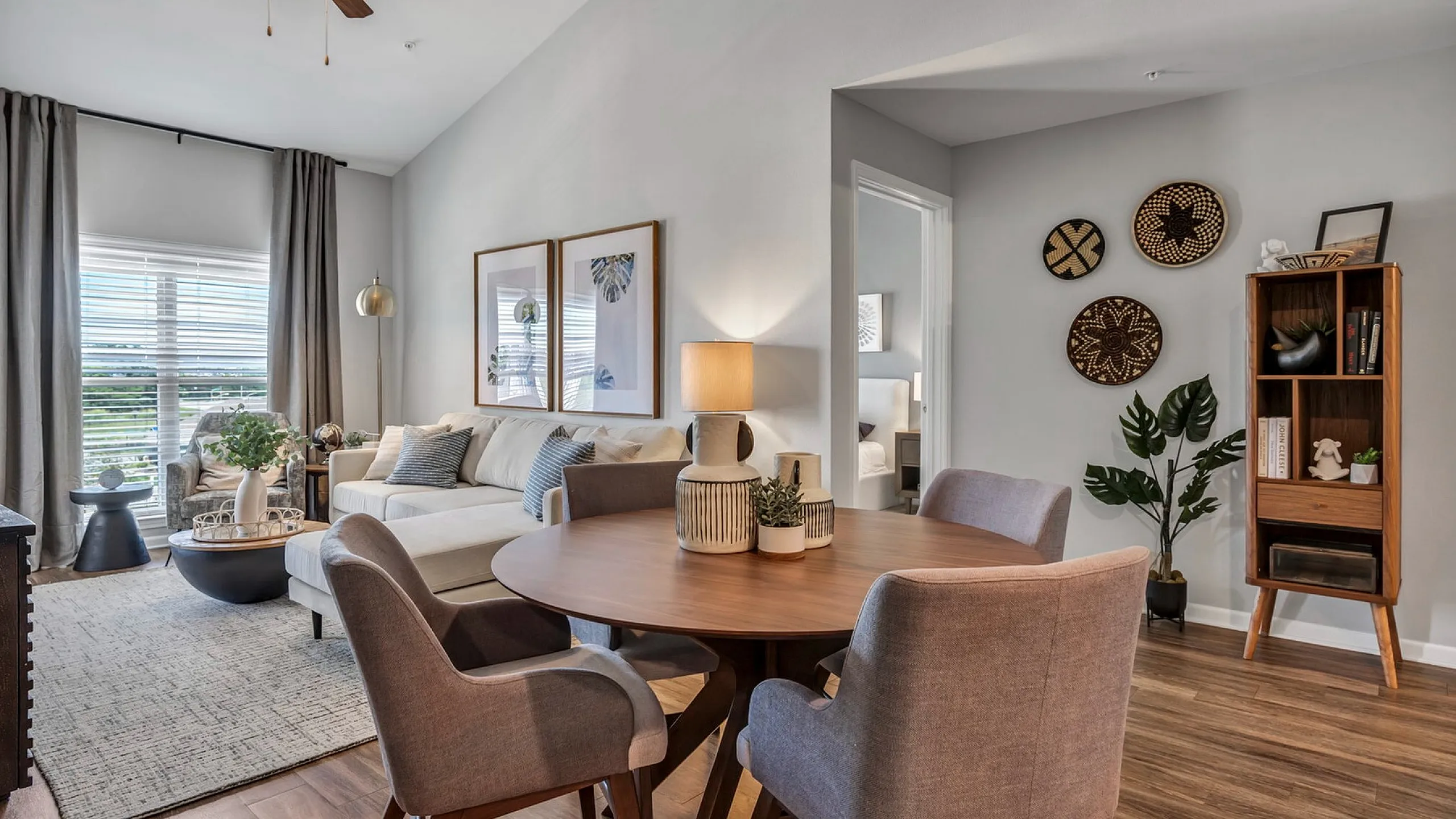 Chic apartment living room with modern decor, featuring cozy seating, natural light, and a stylish dining area, perfect for relaxation and entertaining.