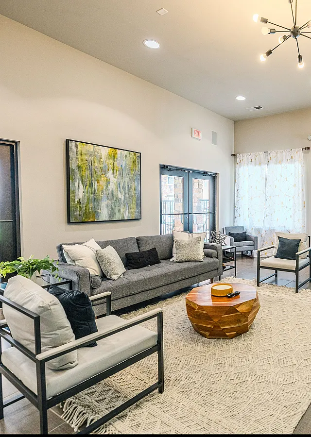 Modern apartment clubhouse featuring cozy lounge seating, stylish decor, and large windows at Watermark at Jordan Creek.