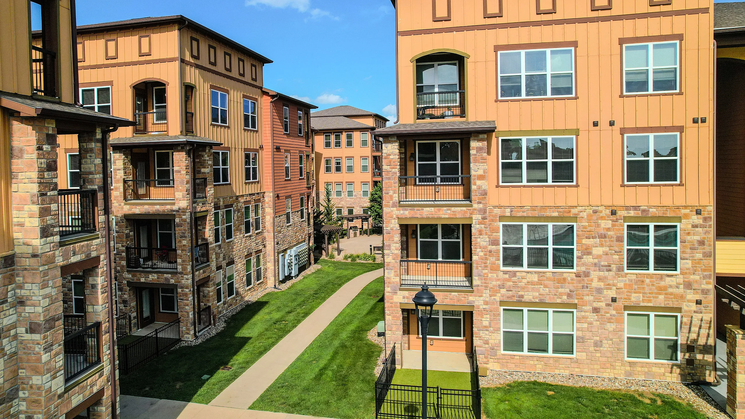 Exterior view of the Watermark at Jordan Creek apartment building featuring modern architecture, balconies, and landscaped grounds.