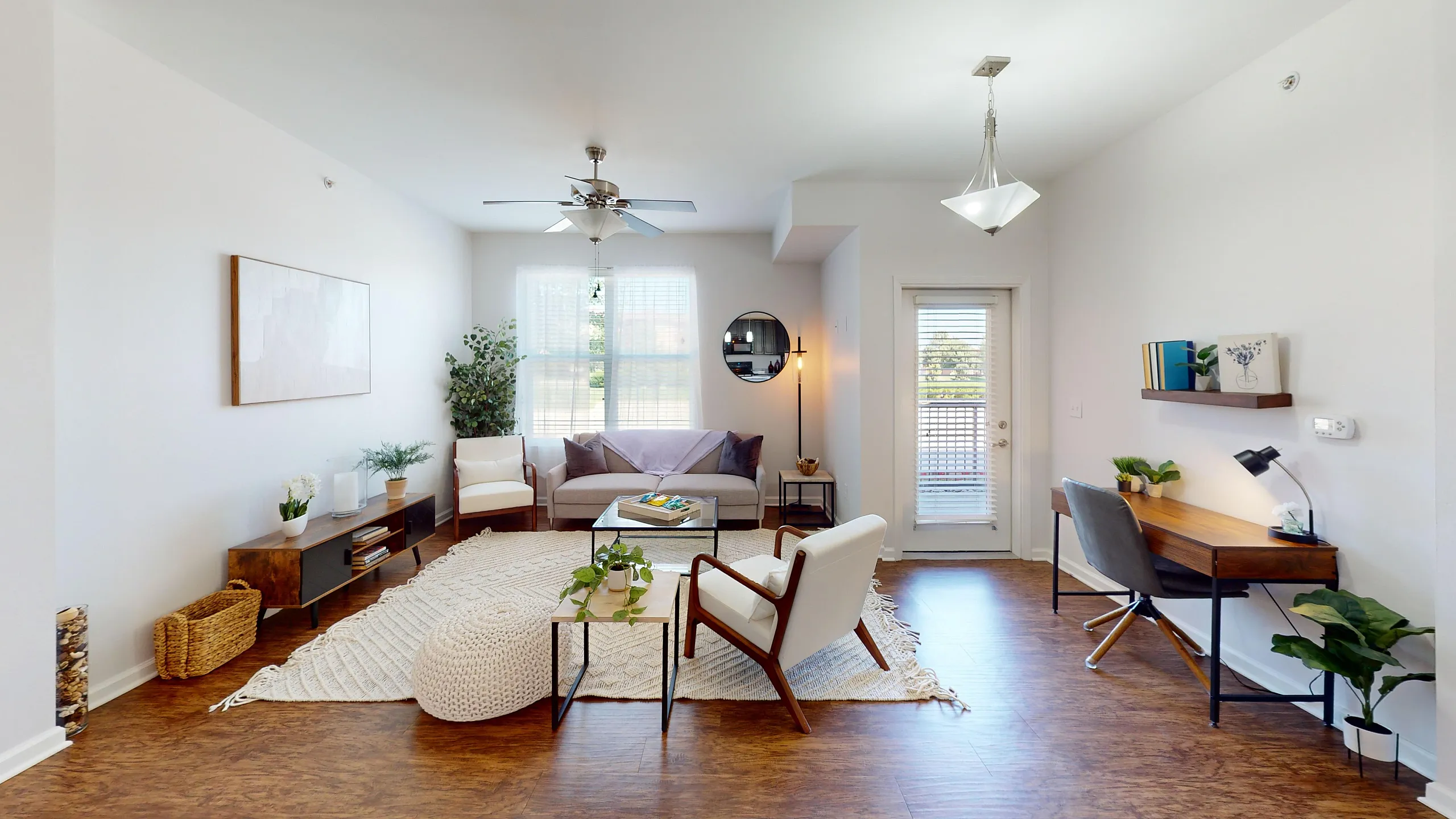 Bright, open-concept apartment living room at Watermark at Jordan Creek featuring large windows, comfortable seating, and modern decor.