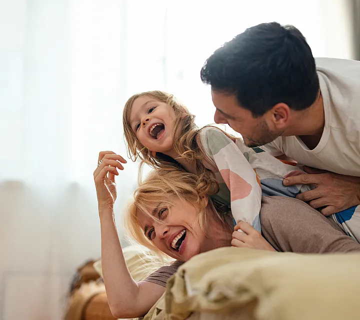 Joyful family enjoying quality time together in a cozy, sunlit living room.
