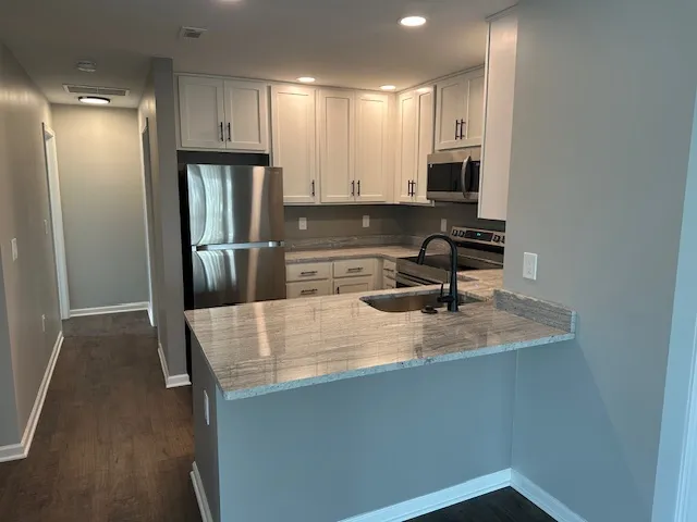 Modern kitchen with elegant cabinets, sleek stainless steel appliances, and a spacious marble countertop, perfect for culinary enthusiasts.