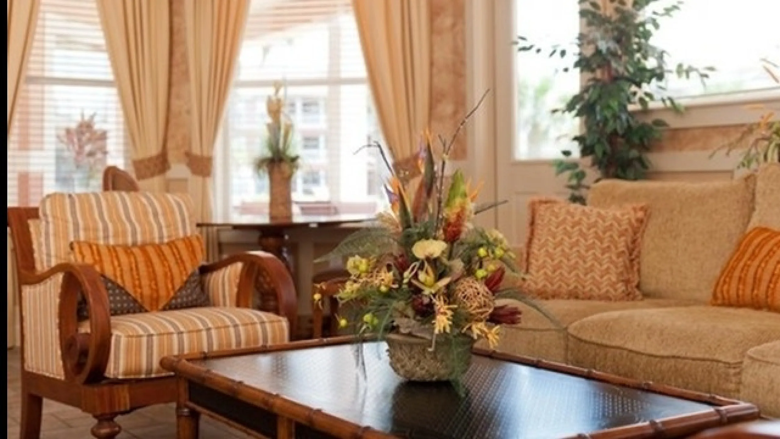 Inviting living room with tasteful decor, featuring warm tones, plush seating, and a floral centerpiece.