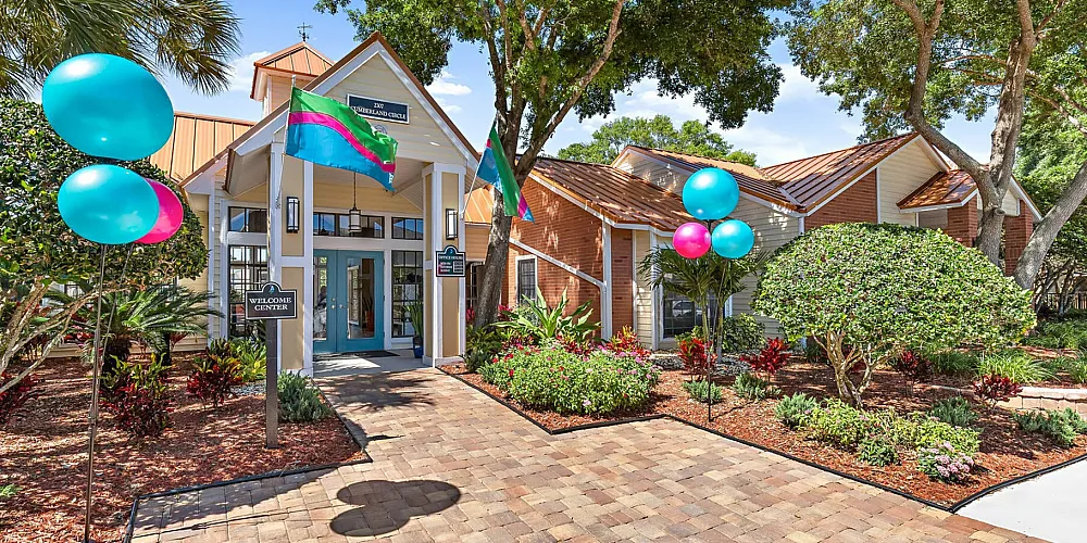 Inviting front view of a welcome center adorned with colorful balloons and lush landscaping.
