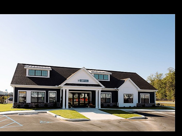 Charming residential building with a modern design, featuring large windows, inviting entryway, and well-maintained landscaping.