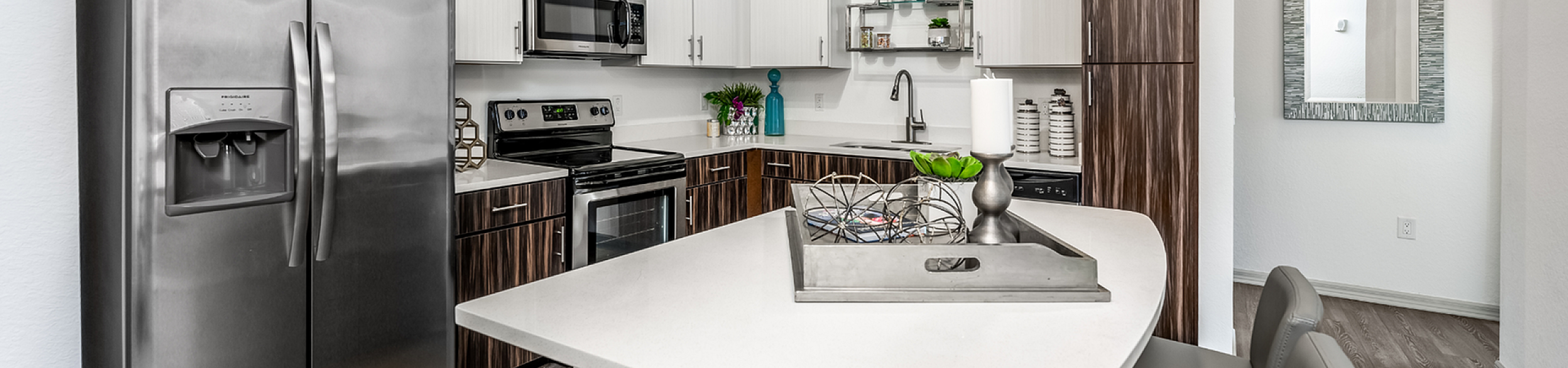 Sleek modern kitchen with stainless steel appliances, an island with seating, and stylish cabinetry.
