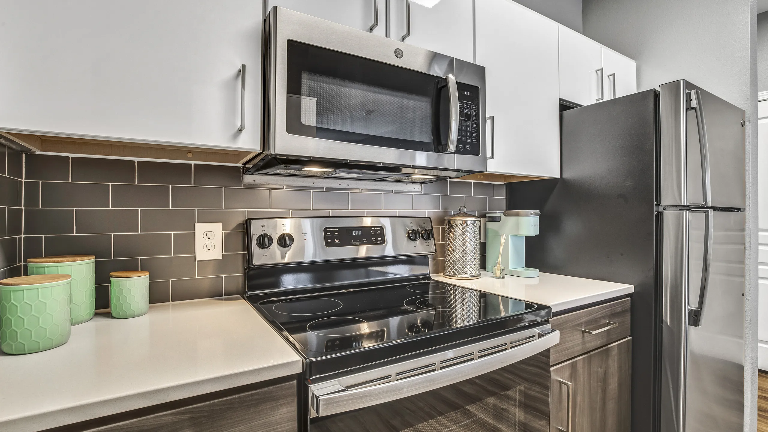 Contemporary kitchen with sleek stainless steel appliances, subway tile backsplash, and stylish countertops.