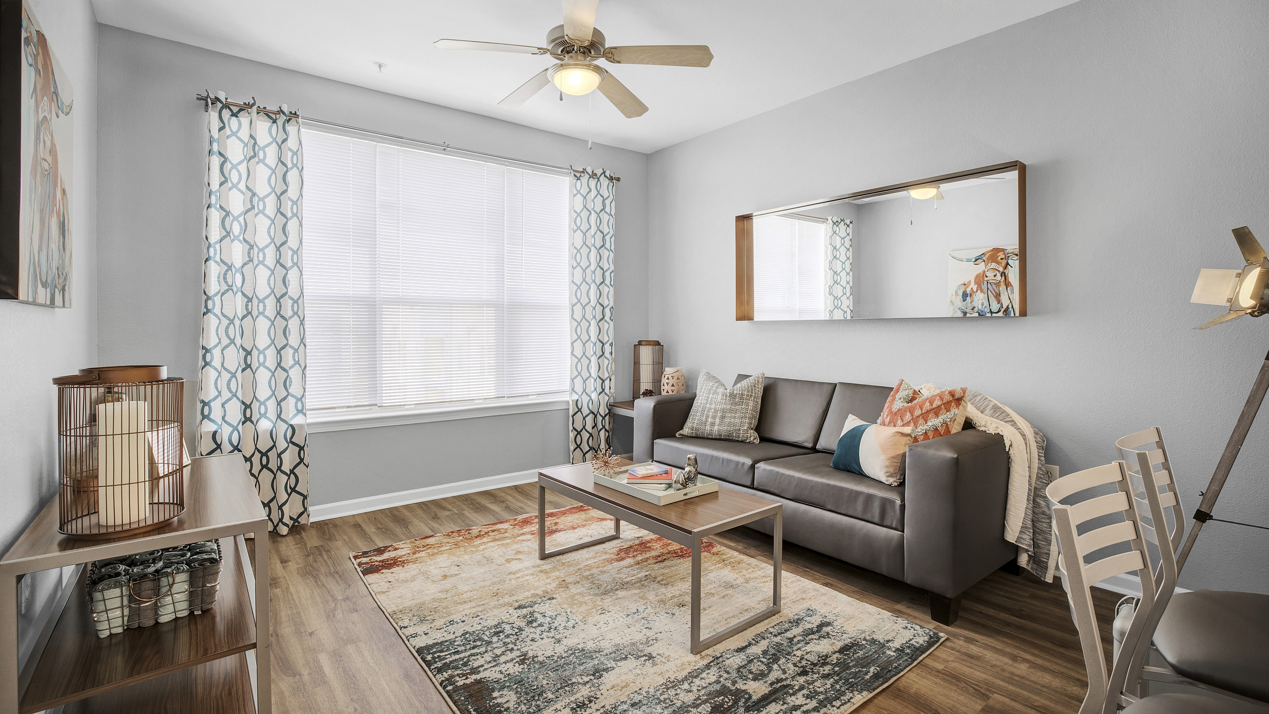 Bright and cozy living room with a gray sofa, modern decor, and natural light.