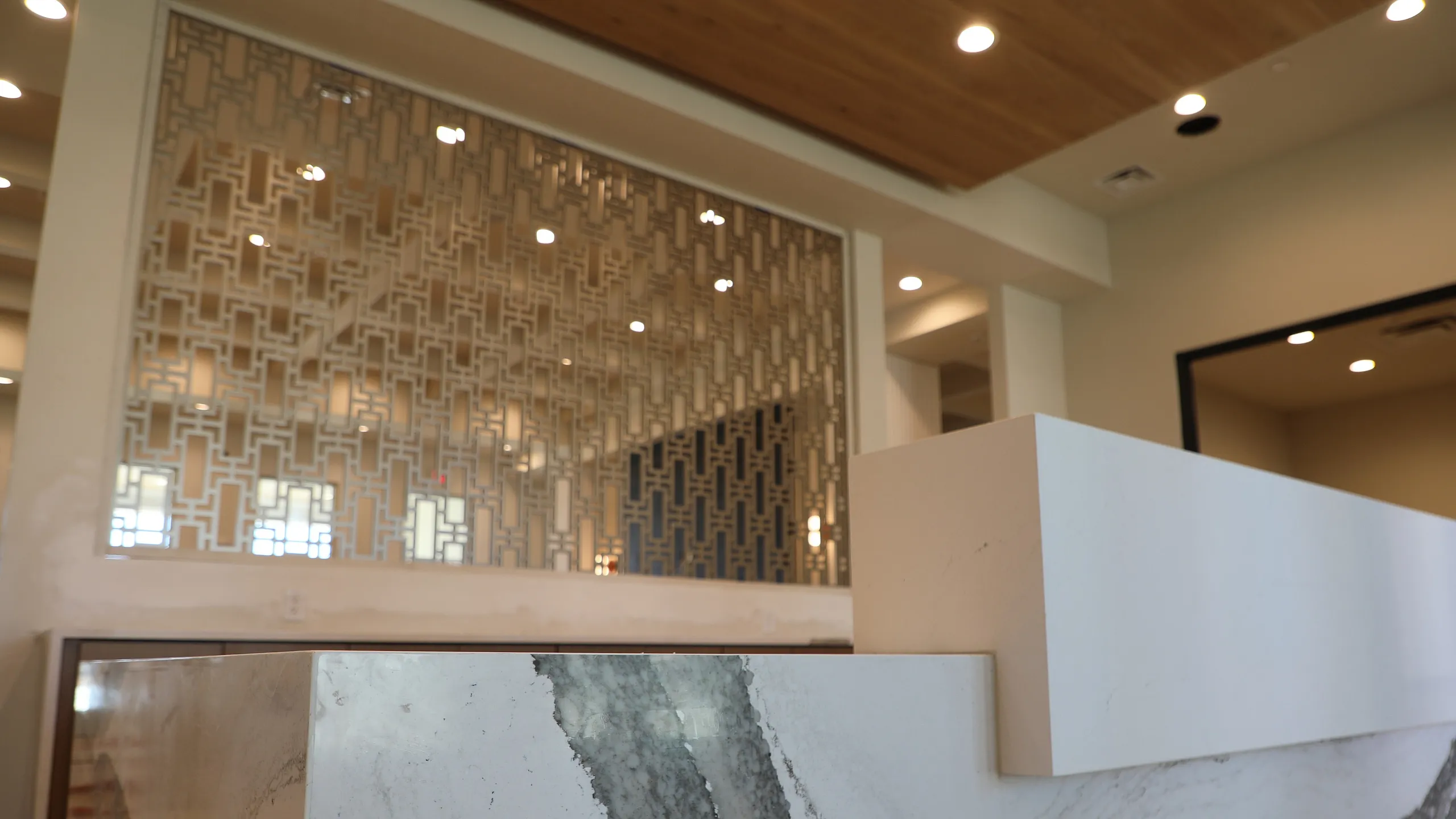 Chic modern interior featuring elegant marble surfaces and a stylish geometric partition.