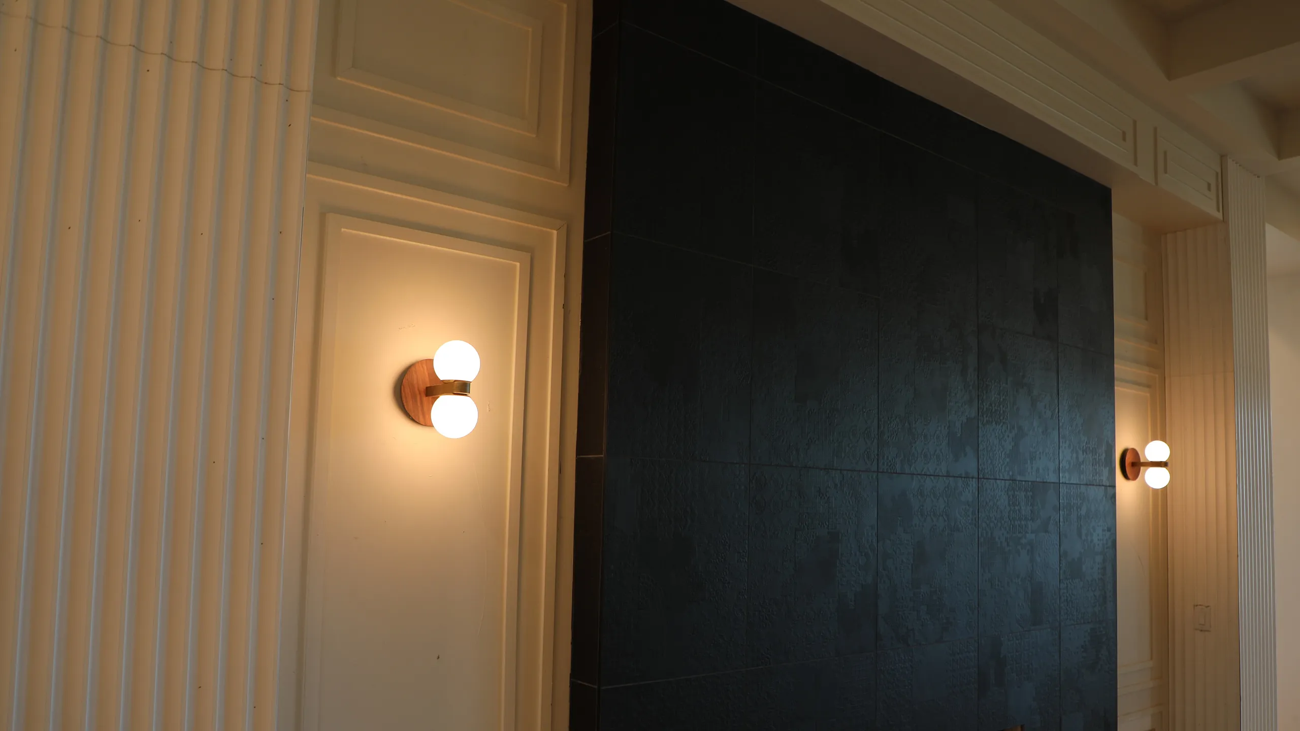 Elegant interior featuring a modern black textured wall with ambient wall lighting, perfect for a cozy living space.
