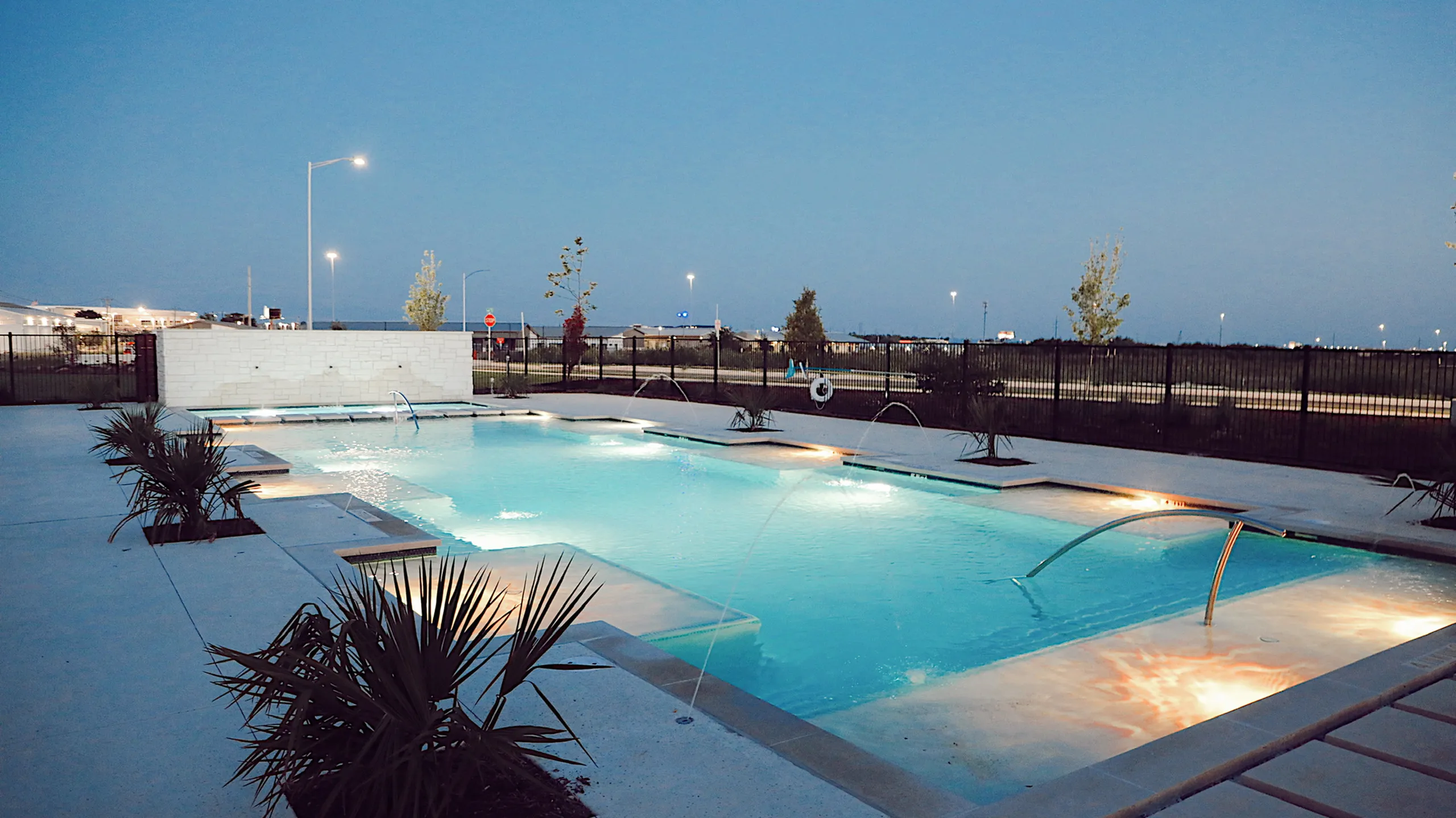 Inviting outdoor pool with ambient evening lighting and modern landscape design, perfect for relaxation.