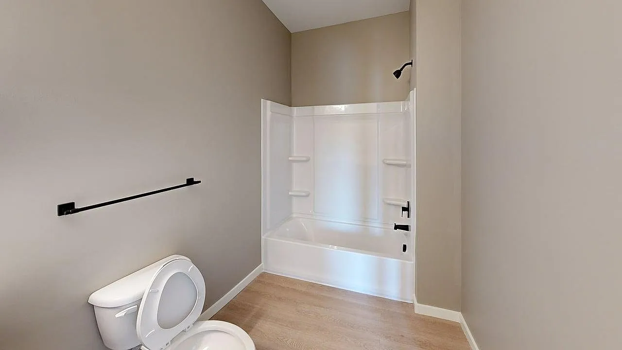 Modern bathroom with sleek fixtures, featuring a pristine bathtub and chic flooring for a luxurious touch.
