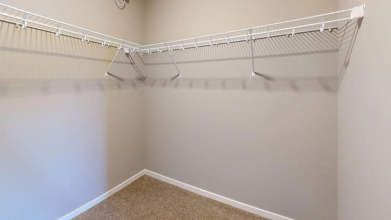 Spacious walk-in closet with elegant shelving, perfect for organized living.