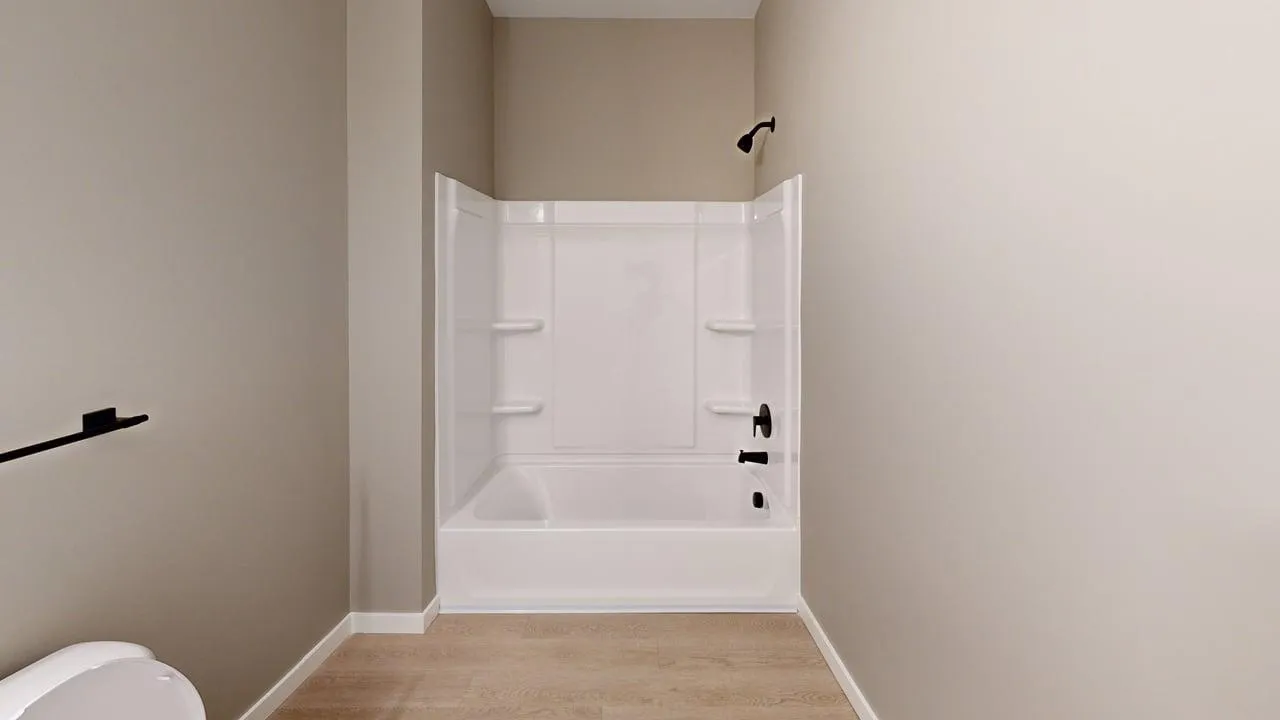 Elegant bathroom with a pristine white bathtub, modern fixtures, and sleek neutral walls.