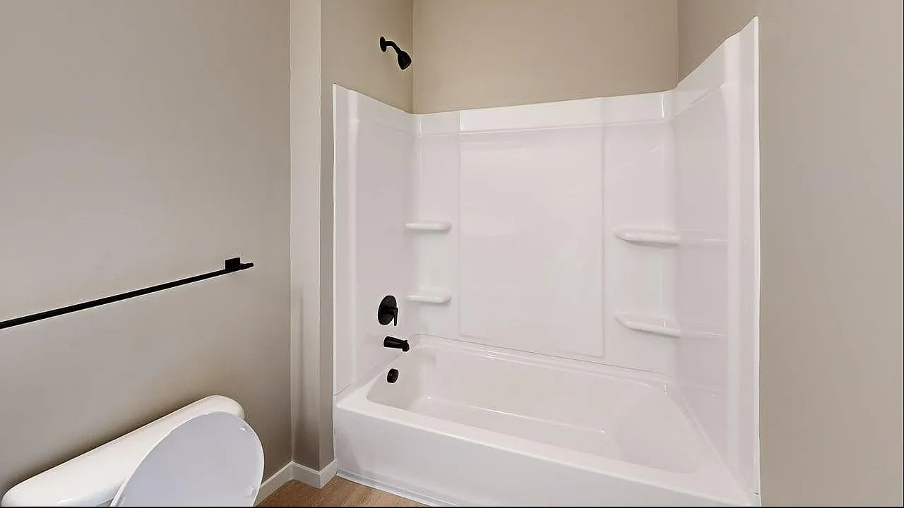 Modern bathroom with a sleek white bathtub and neutral-toned walls, offering a refreshing and minimalistic design.