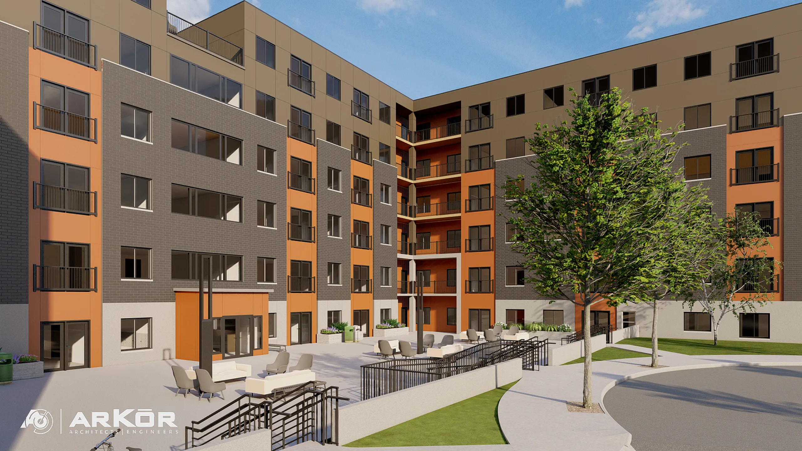 Modern apartment complex with vibrant orange and gray facade, featuring spacious outdoor seating area and lush landscaping.