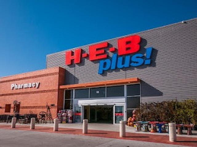 Vibrant H-E-B Plus facade under a clear blue sky, showcasing the inviting entrance and modern architectural design.