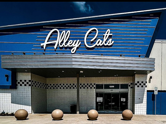 Inviting bowling alley entrance with a sleek modern design and vibrant blue accents.