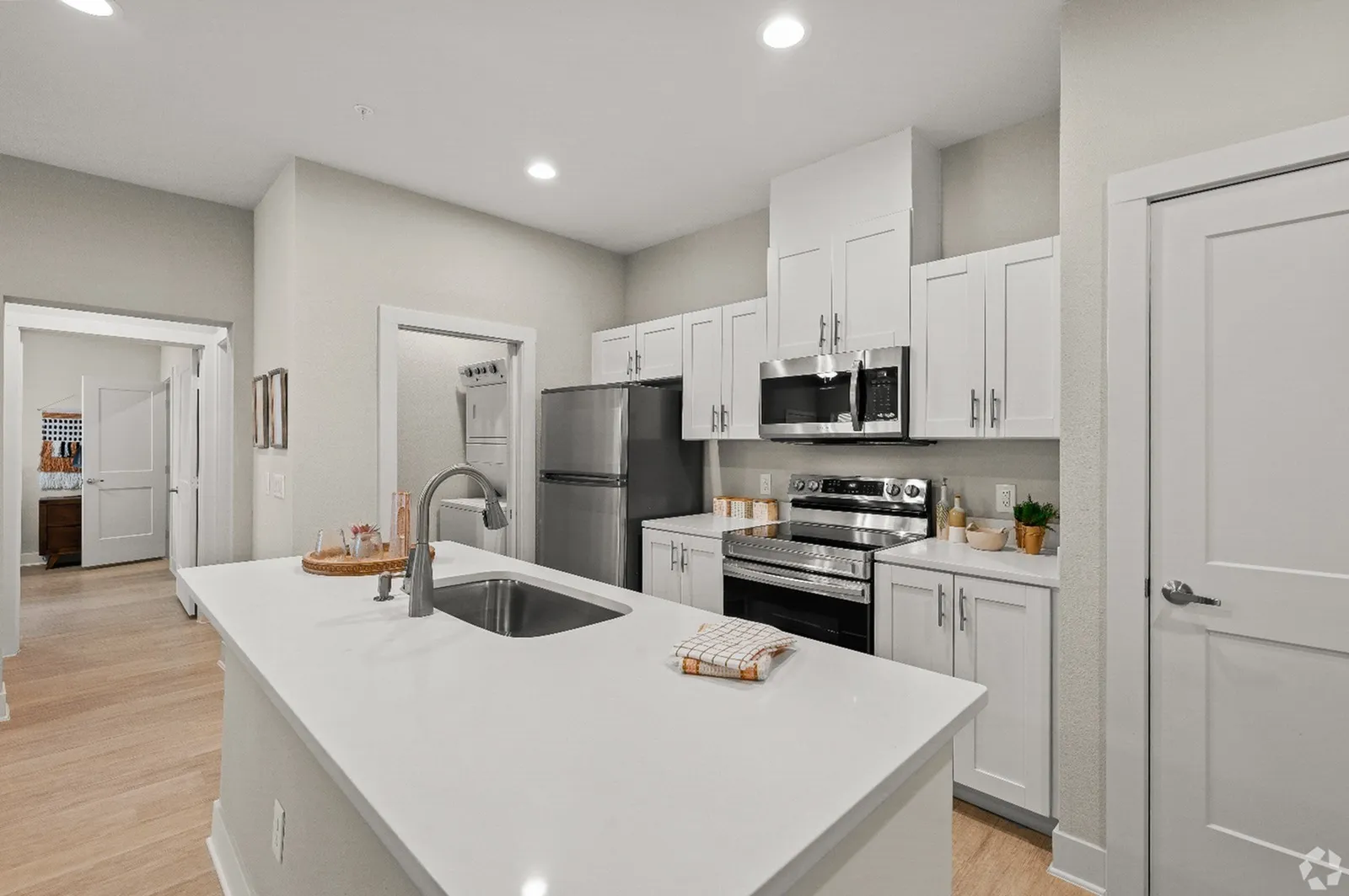 Modern, sleek kitchen design with stainless steel appliances, elegant white cabinetry, and a spacious island countertop, creating a bright and inviting atmosphere.